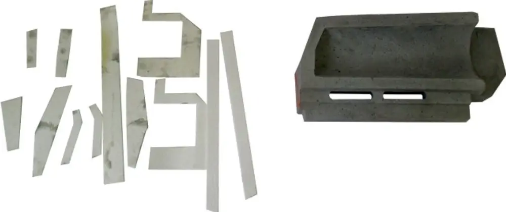 Zwei separate Stücke, eines aus hellen, flachen Materialien und ein grauer, rechteckiger Block mit Aussparung, möglicherweise für die Brennkammer von Wolf-Produkten.